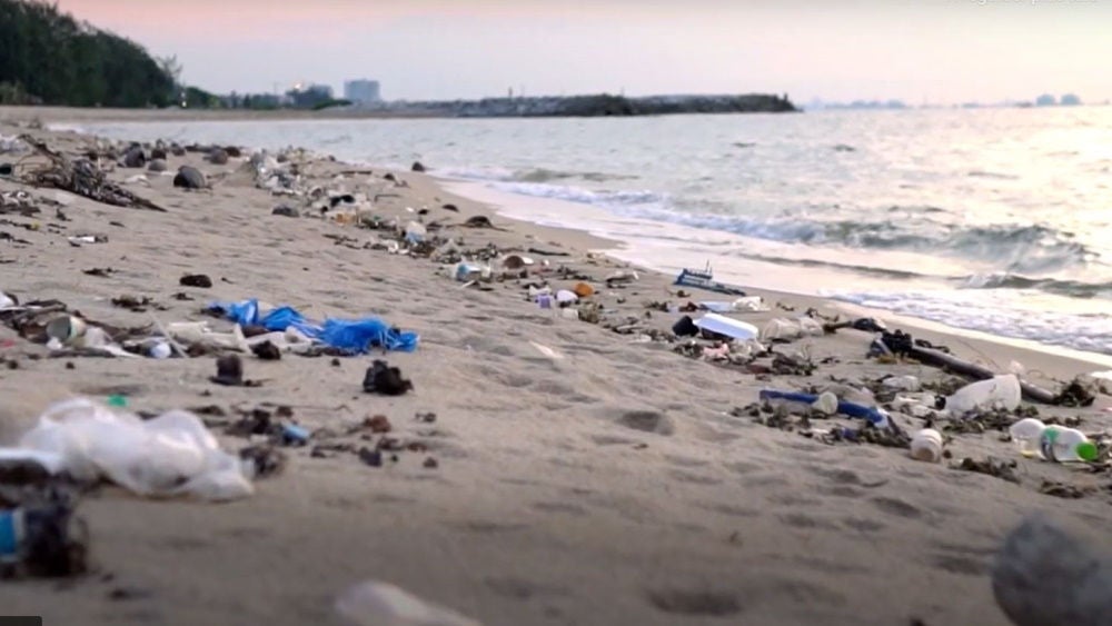 Stranden full av plastavfall