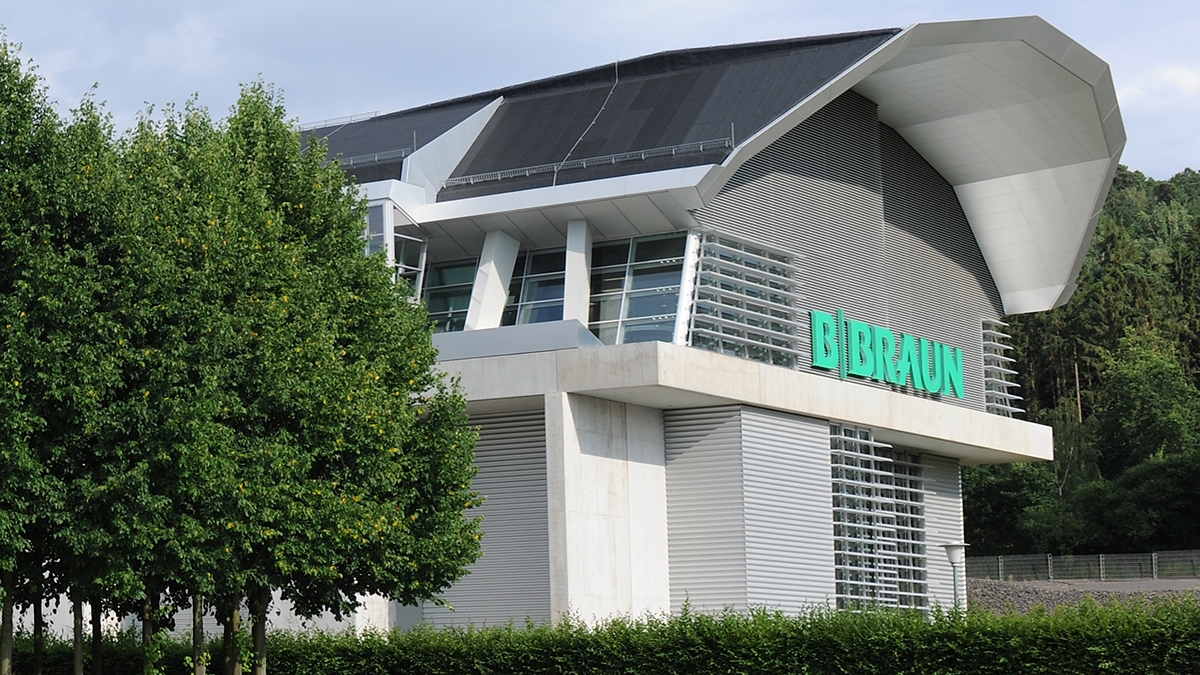 B. Brauns besökscenterbyggnad med en stor B. Braun-logotyp som utstrålar gästfrihet och öppenhet till alla som närmar sig. 