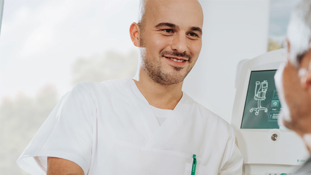 sjuksköterska som pratar med en patient medan hon ansluter till omni