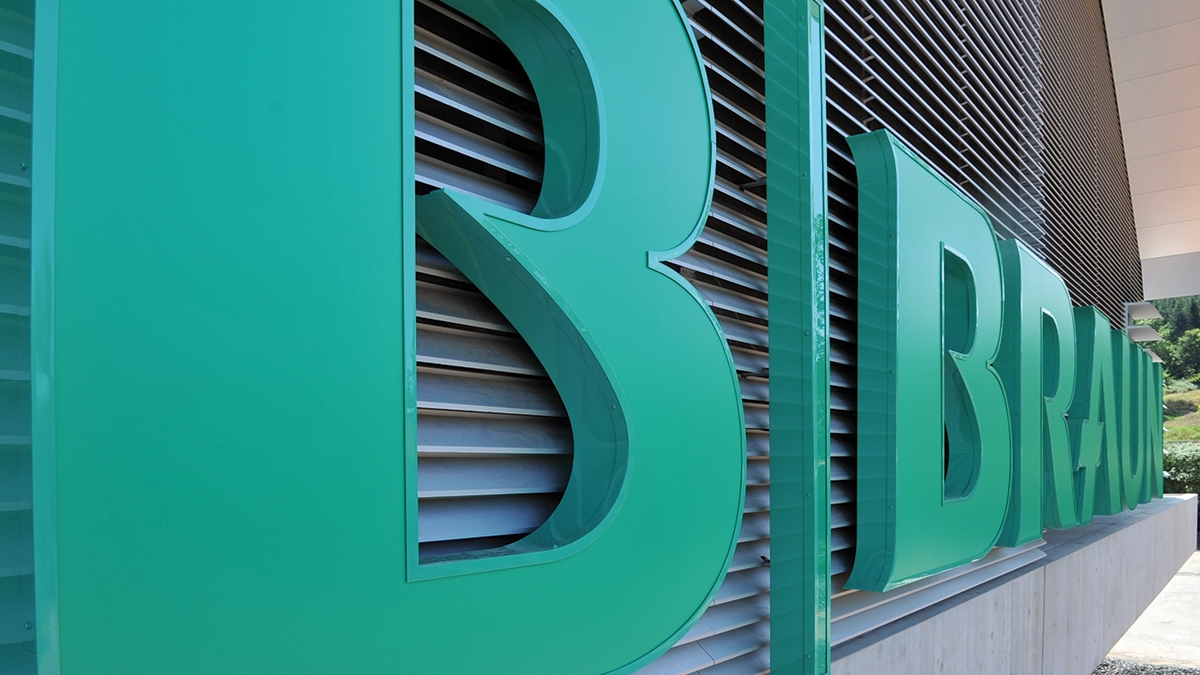 Närbild på en tredimensionell B. Braun-logotyp på en modern byggnadsfasad