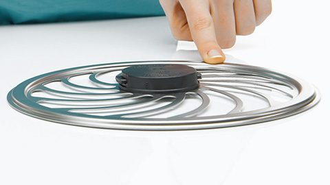 En hand vidrör ett hjulformat metallföremål som kan vara en del av en medicinsk enhet eller utrustning