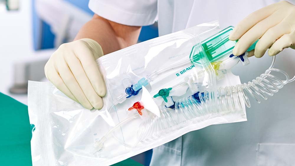 En vårdpersonal tar ut ett förberett medicinskt instrument från B. Braun ur sin sterila förpackningar.